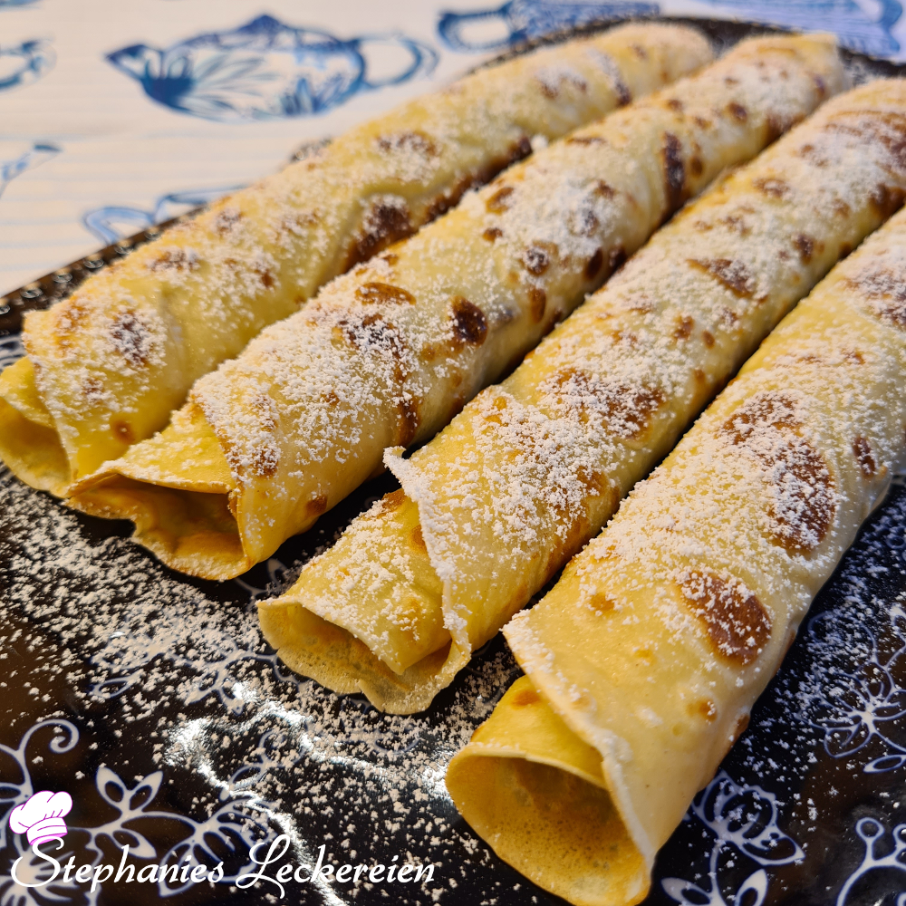 Palačinke, mit Schokoladencreme gefüllt und Puderzucker bestreut.